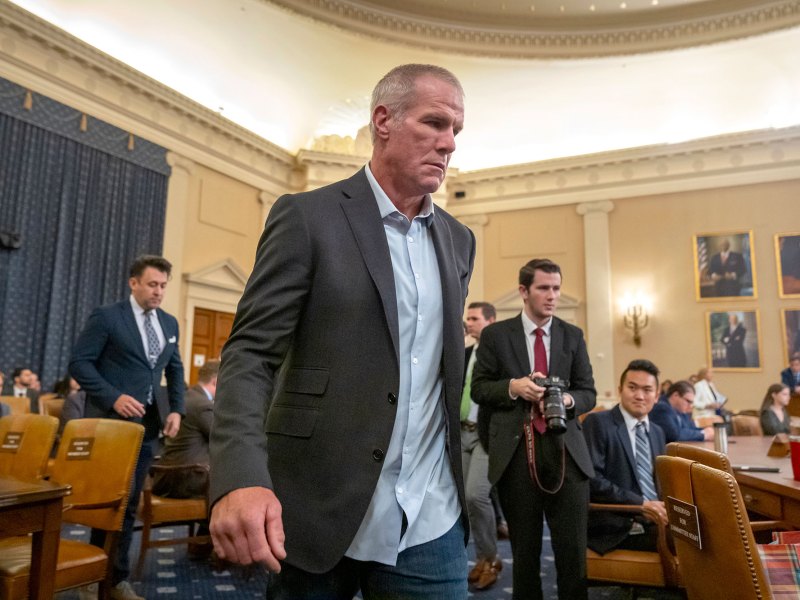 A man in a suit walks through a busy room