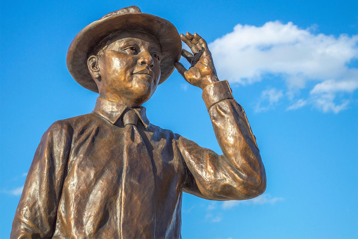 Bronze statue of Emmett Till against a blue sky