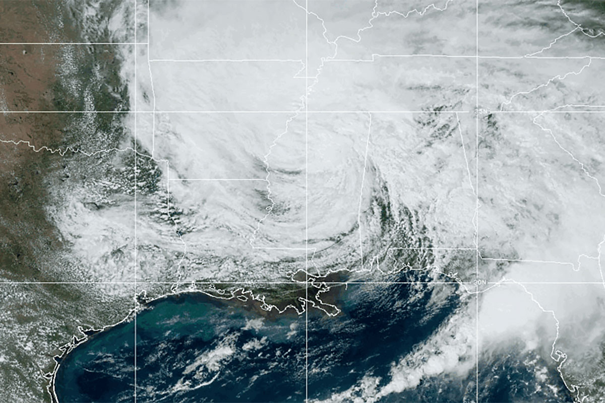 A weather map view of a large spiral of white clouds obscuring the US South