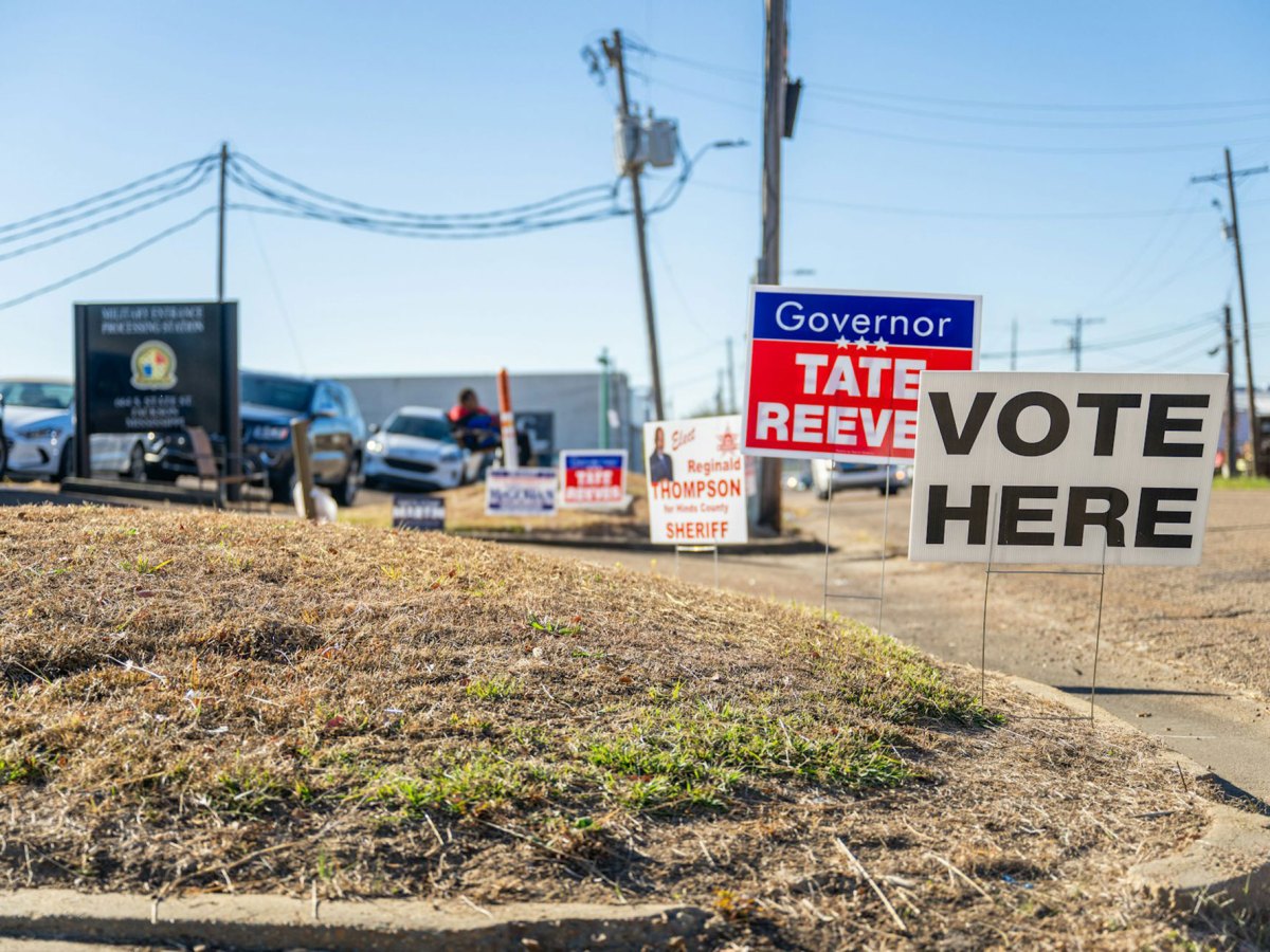 Signs outside of a voting precinct that say Vote Here