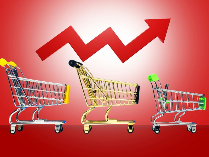 A graphic of three shopping carts against a red background, with a red arrow zig zagging up