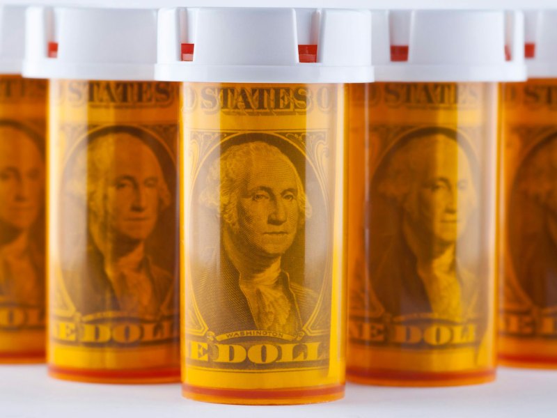 Orange pill bottles filled with dollar bills