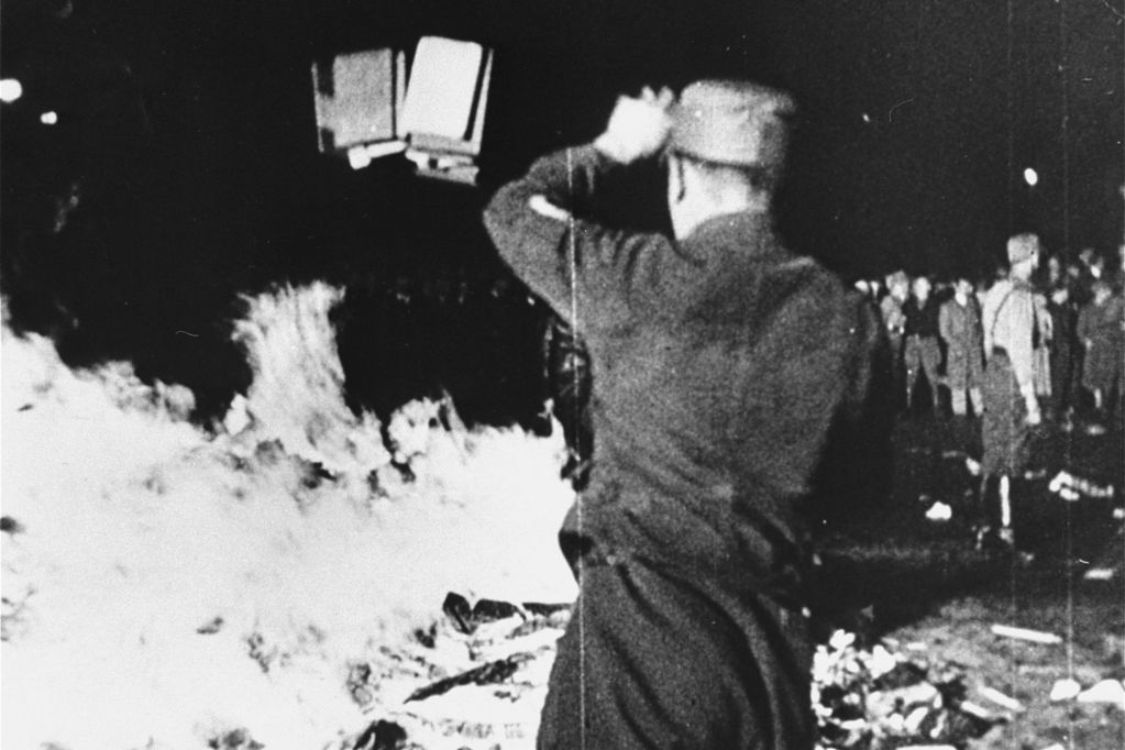 A member of the SA throws confiscated books into the bonfire during the public burning of "un-German" books on the Opernplatz in Berlin