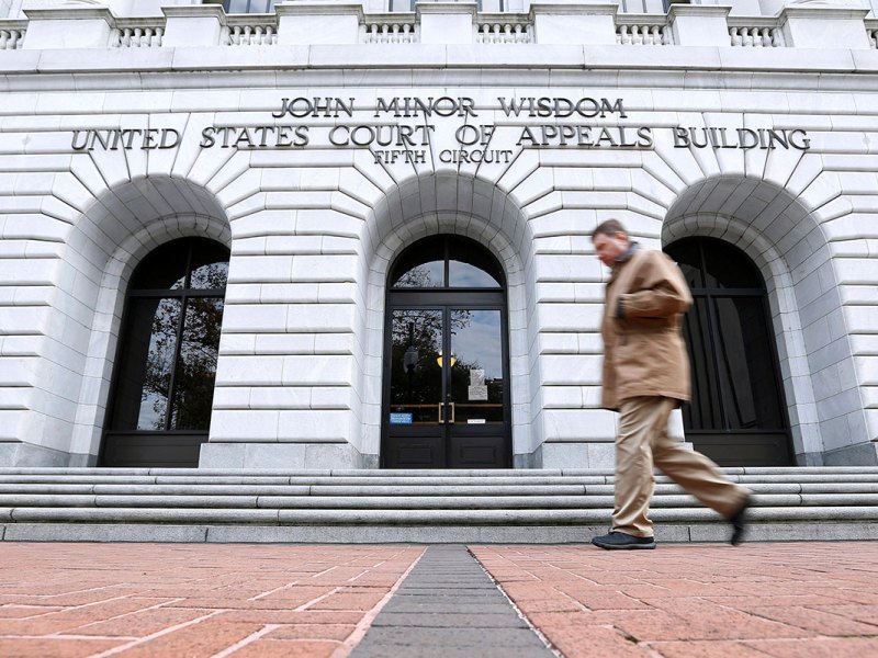a photo of a man walking path the 5th Circuit Court building
