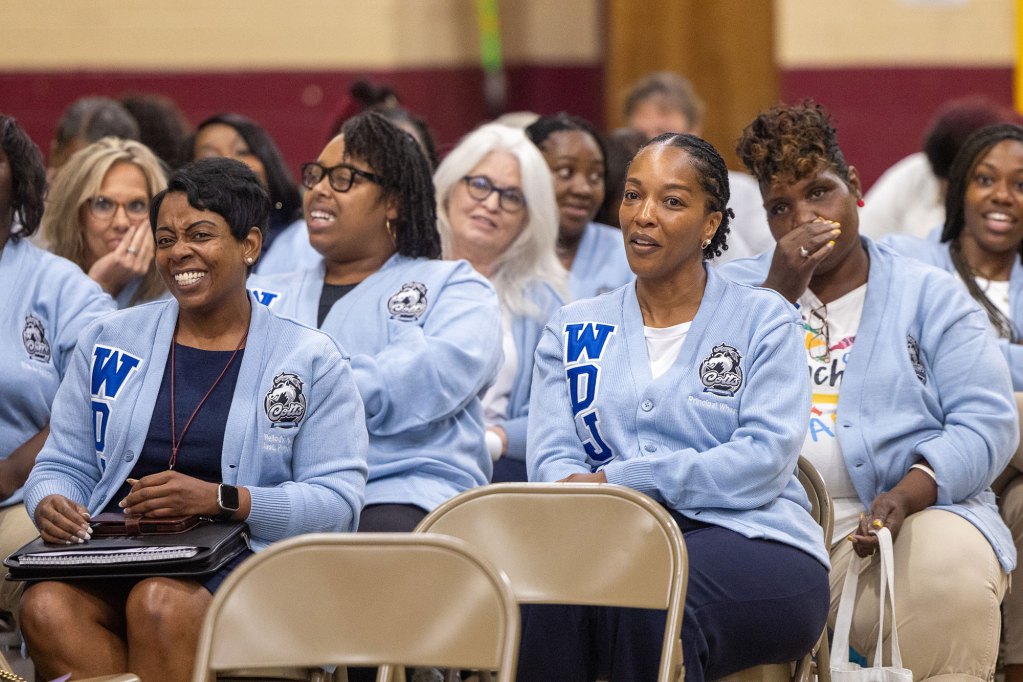 Women teachers sitting inside a school auditorium