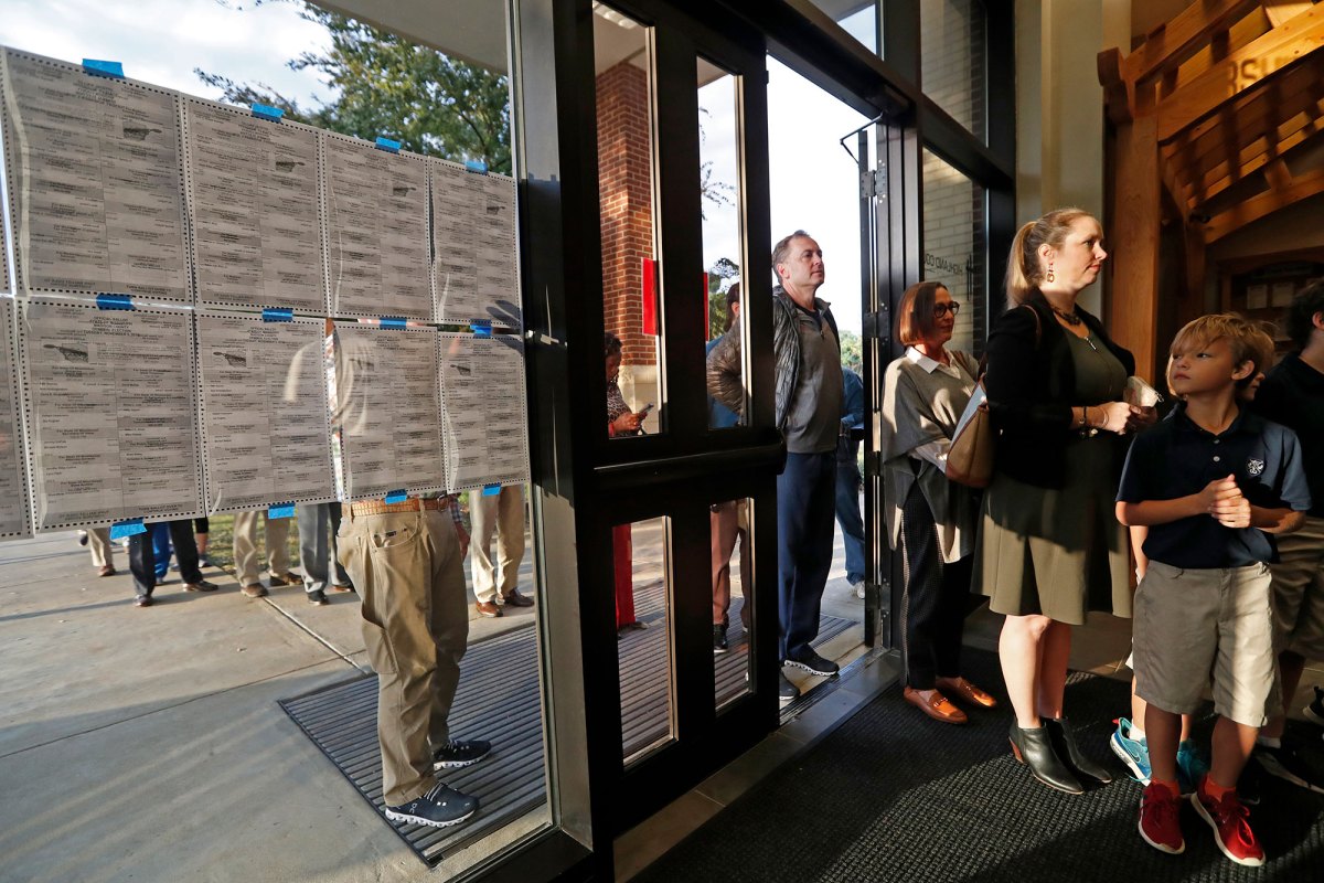 People stand in line through an open doorway to vote