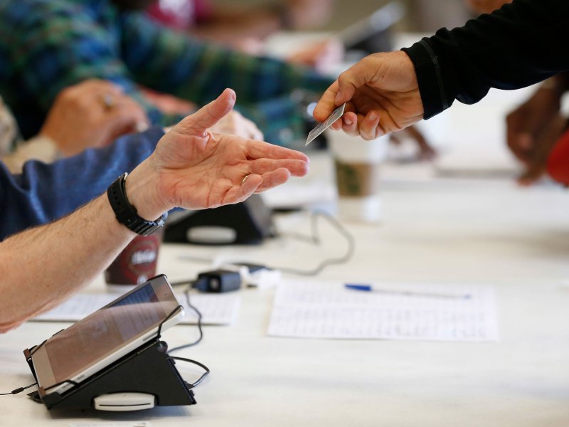 Closeup of a pair of hands exchanging an ID card