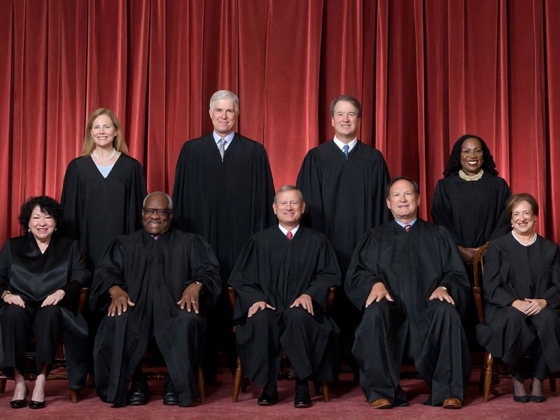 US Supreme Court justices sitting and standing in black robes