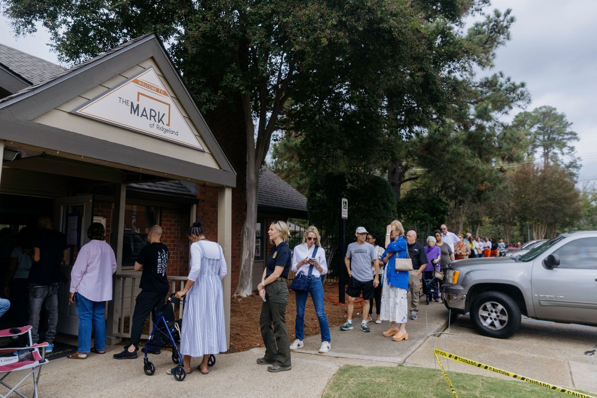 People standing outside of apartment complex waiting to vote