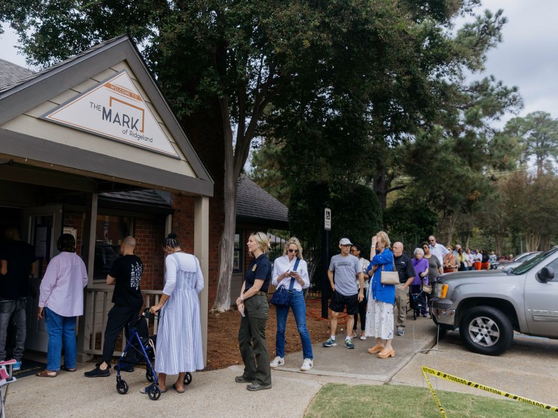 People standing outside of apartment complex waiting to vote