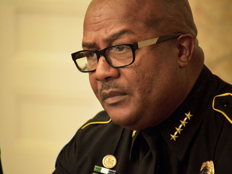 Chief Police officer at a meeting talking with media.