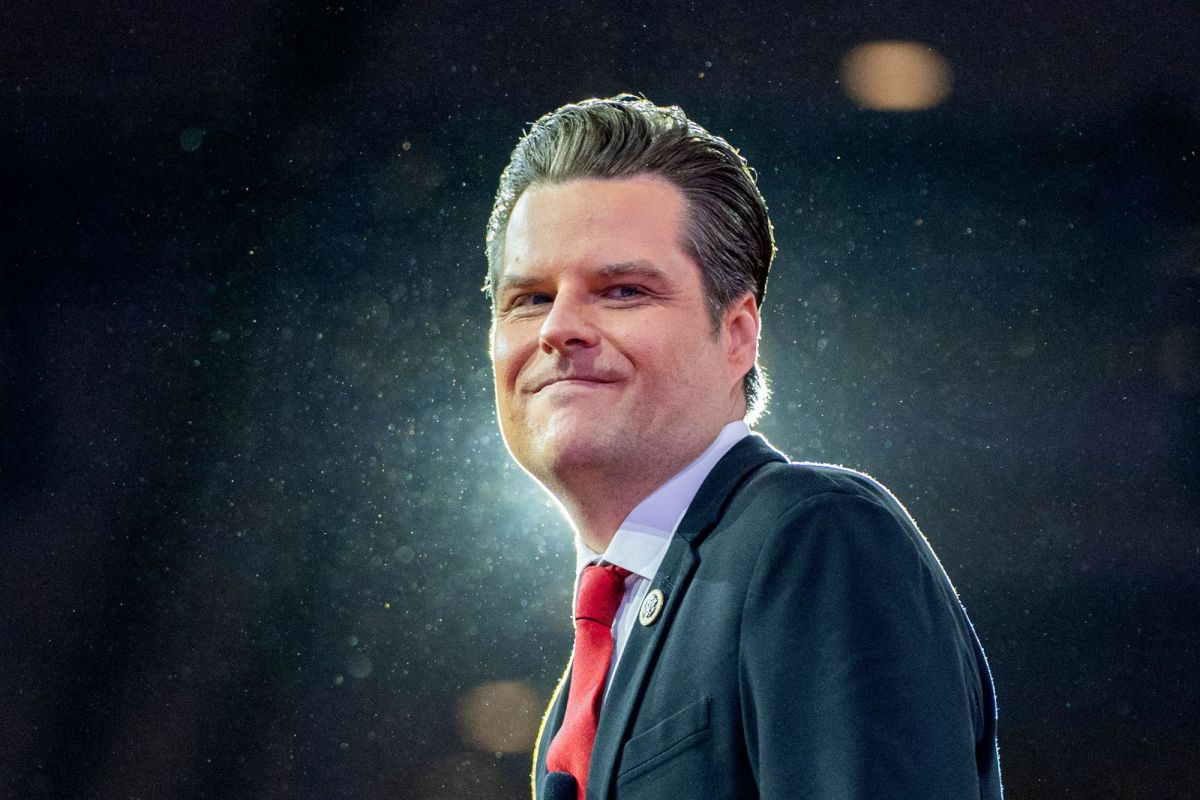 A man in a suit outside in night, backlit on a dark stage