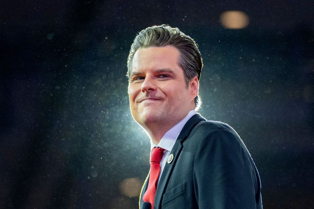 A man in a suit outside in night, backlit on a dark stage