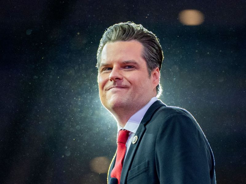 A man in a suit outside in night, backlit on a dark stage