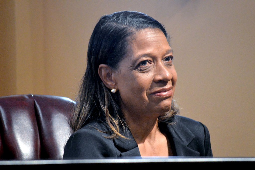 A woman in a black outfit sitting at a desk
