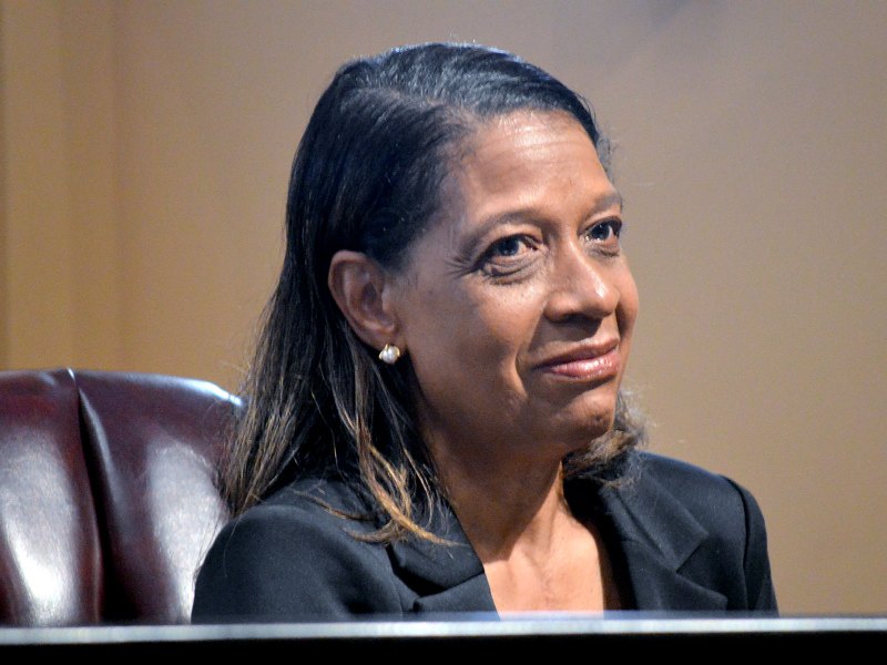 A woman in a black outfit sitting at a desk