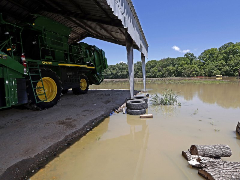 Flood waters surriund a tractor barn