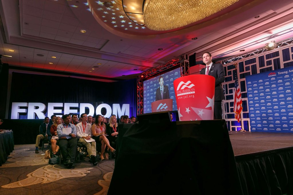 Marco Rubio on a podium with FREEDOM real large behind the audience