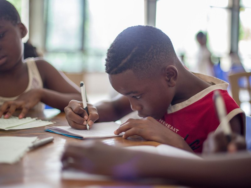 Students writing on paper for class