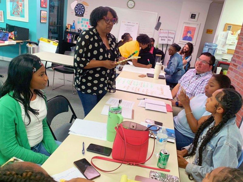 Torsheta Jackson standing at table talking to Youth Media Project and Mississippi Free Press journalists