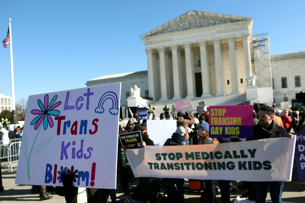 People hold pro and anti trans kids signs outside of the US Supreme Court