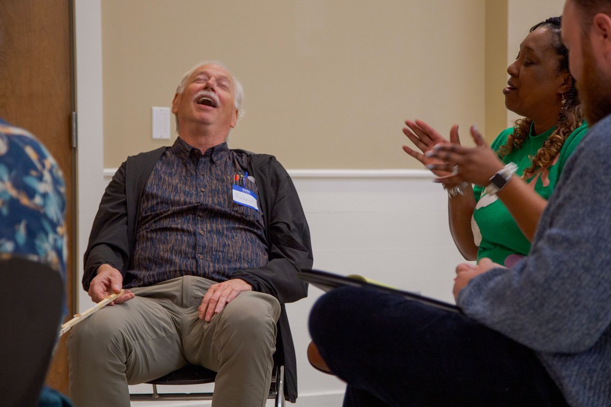 A group of seated people, speaking and laughing