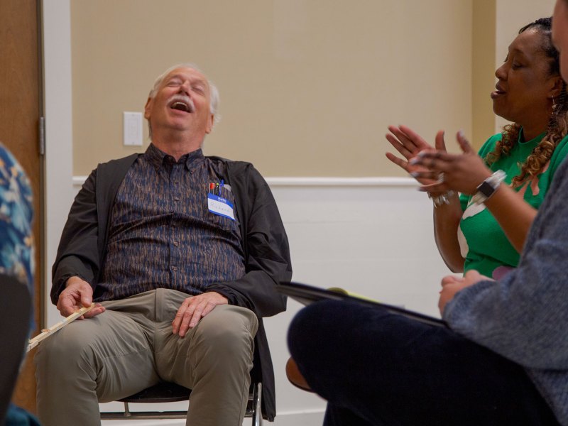 A group of seated people, speaking and laughing