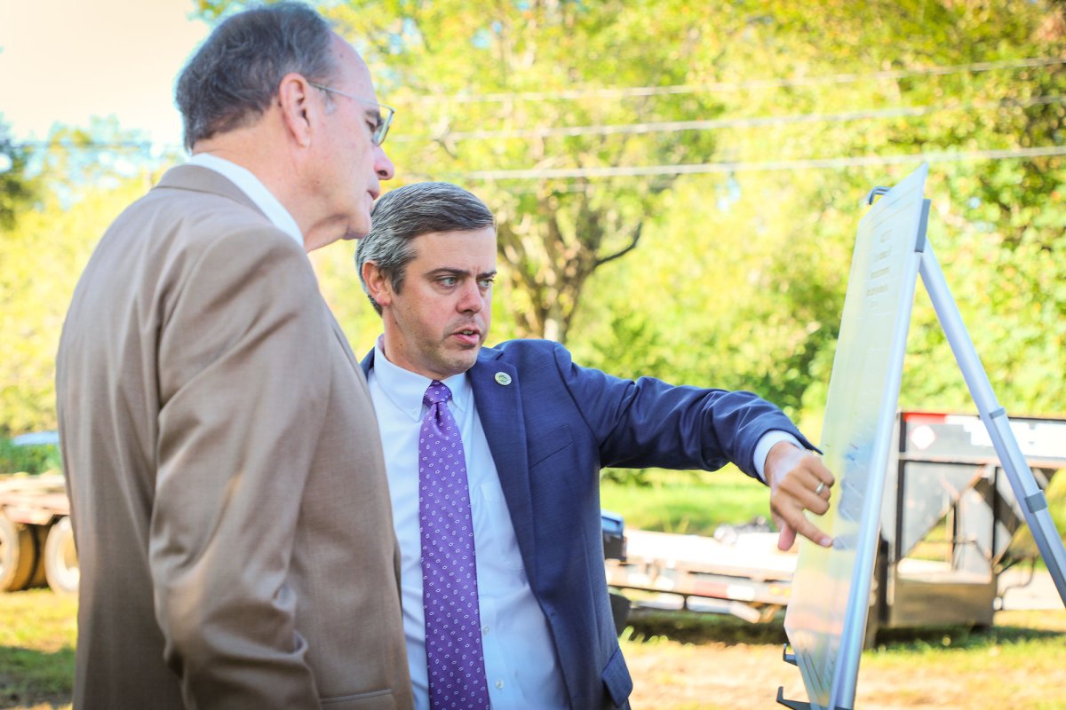 Two men look at an easel outside
