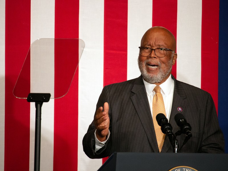 Bennie Thompson speaking at a podium, with the red and white stripes of the US flag behind him