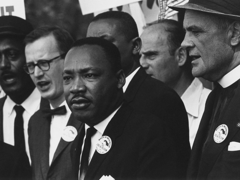 A closeup of Dr. Martin Luther King Jr. speaking in front of a crowd