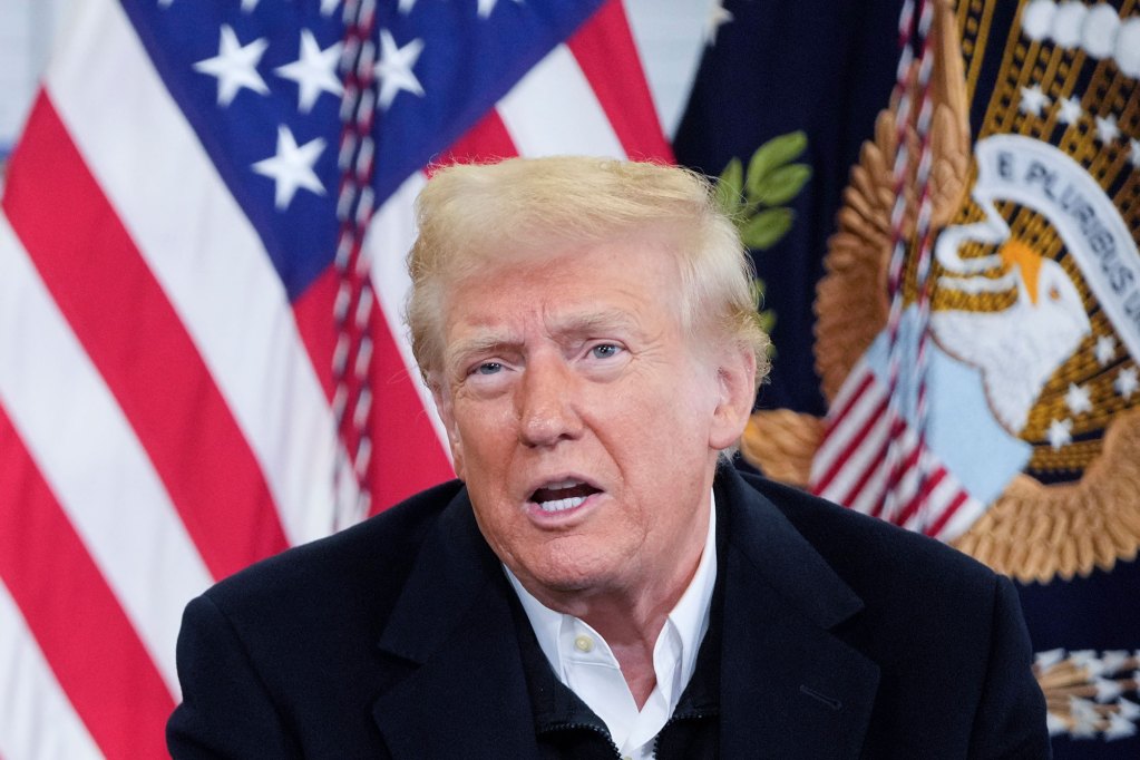 A man sits outside at a table labeled President of the United