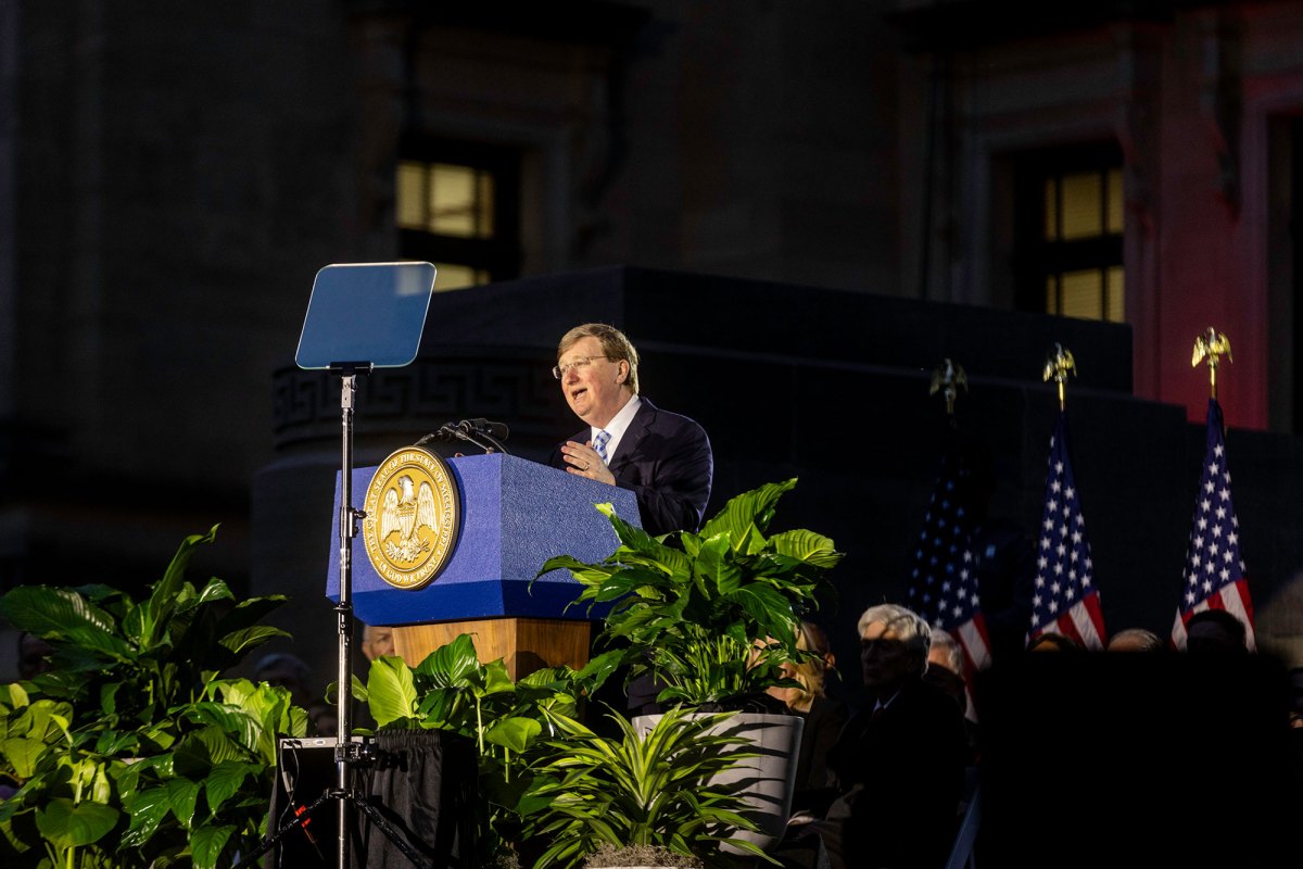 Gov. Tate Reeves speaks from an outside stage at night
