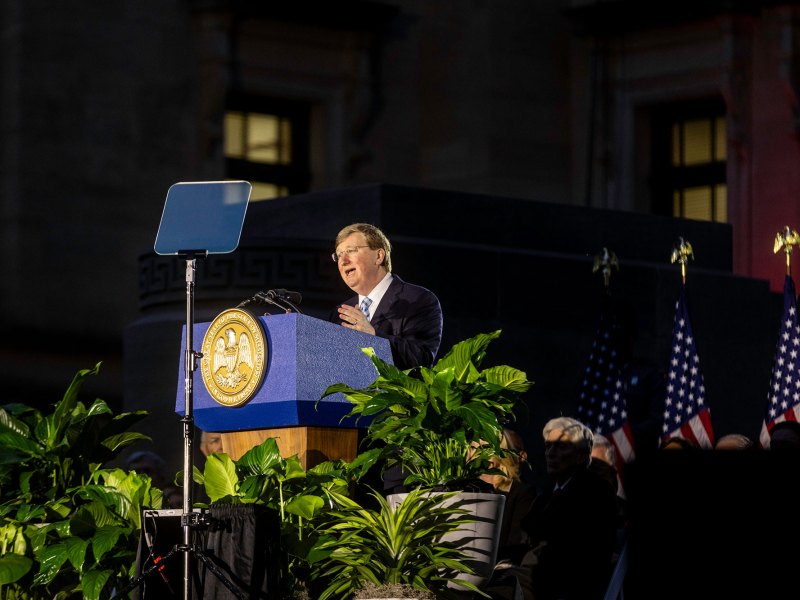 Gov. Tate Reeves speaks from an outside stage at night