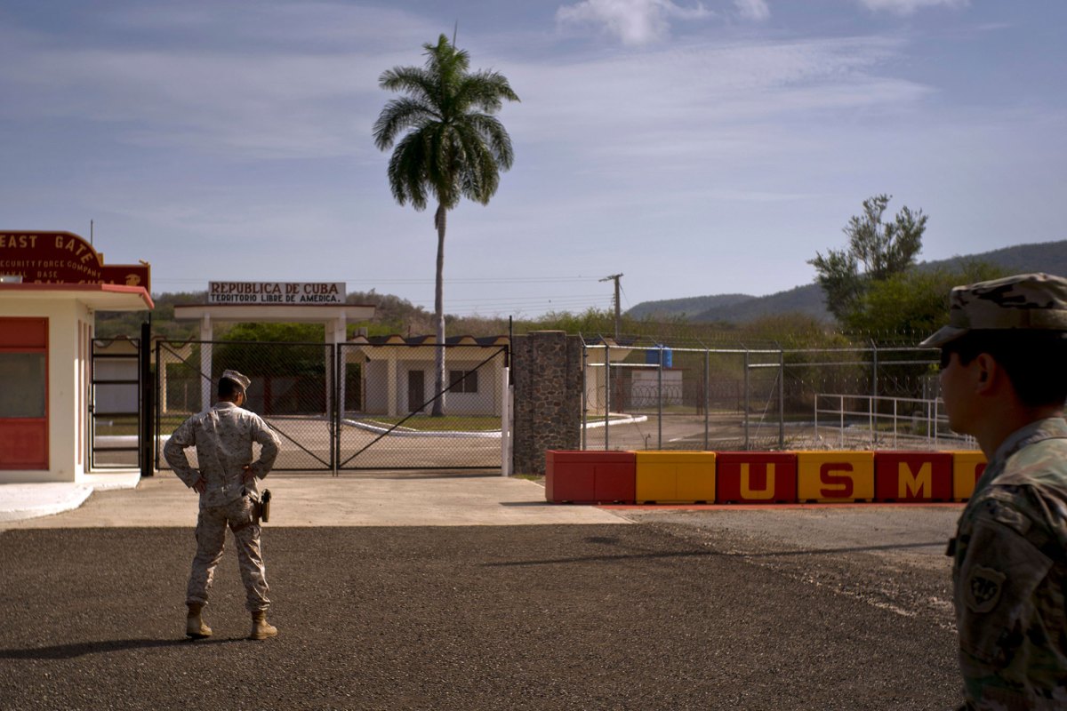 Two soldiers stand outside a military base on Cuba