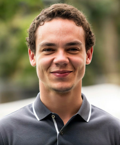 A smiling young man in a grey polo top