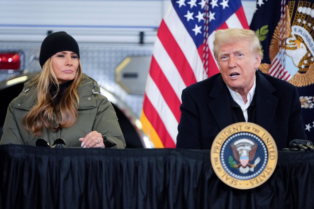Two people sit outside at a table labeled President of the United States