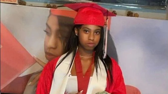 A young woman in red graduation robes and cap