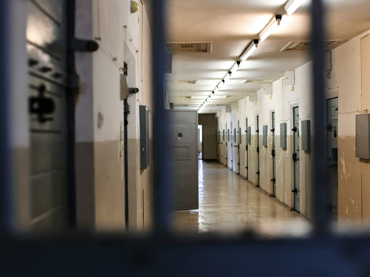 A view of a prison hallway through jail bars
