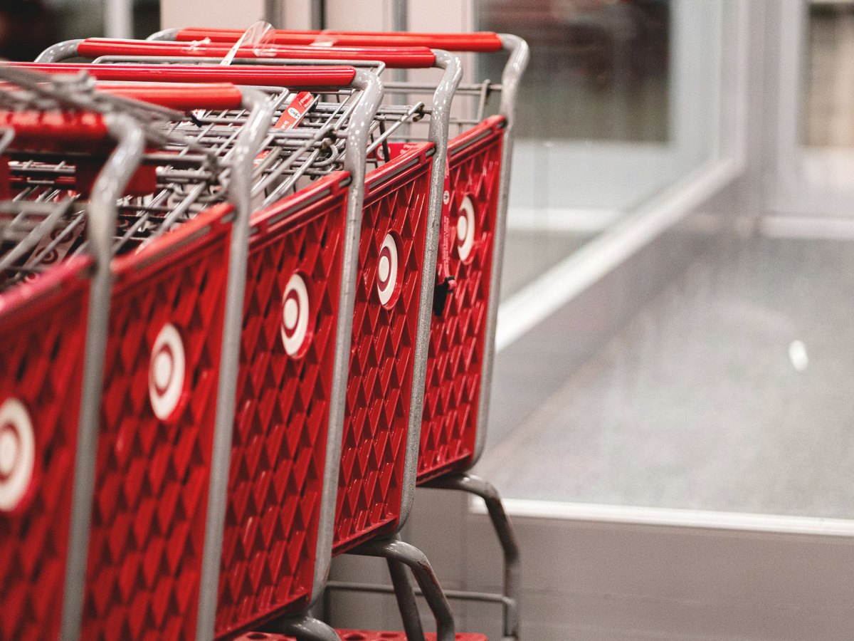 A row of red shopping carts sitting in front of a store