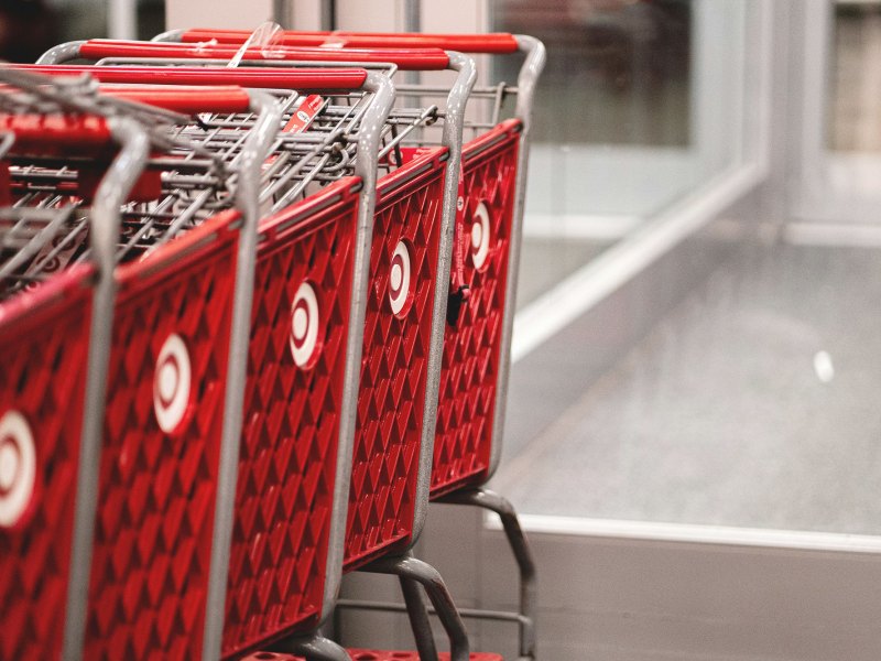 A row of red shopping carts sitting in front of a store