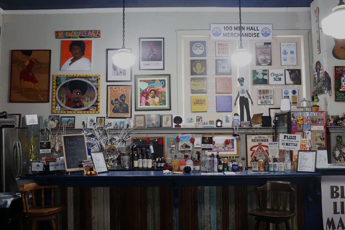 The photo shows a room filled with black art including paintings and posters.