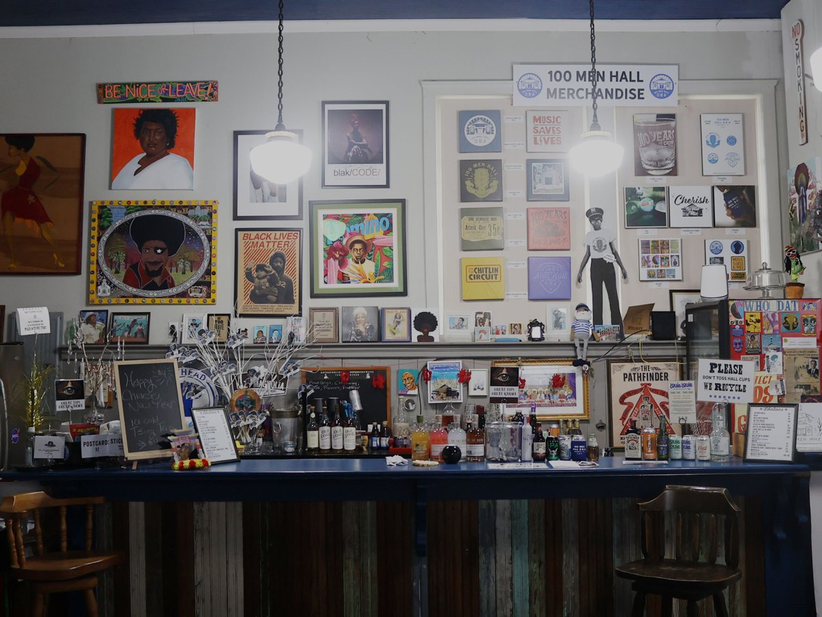 The photo shows a room filled with black art including paintings and posters.