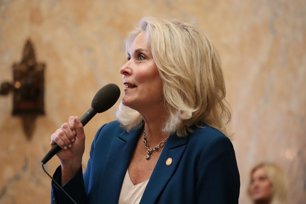 a photo of a woman holding a microphone and speaking