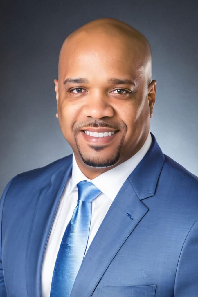 a photo of a man in a suit smiling