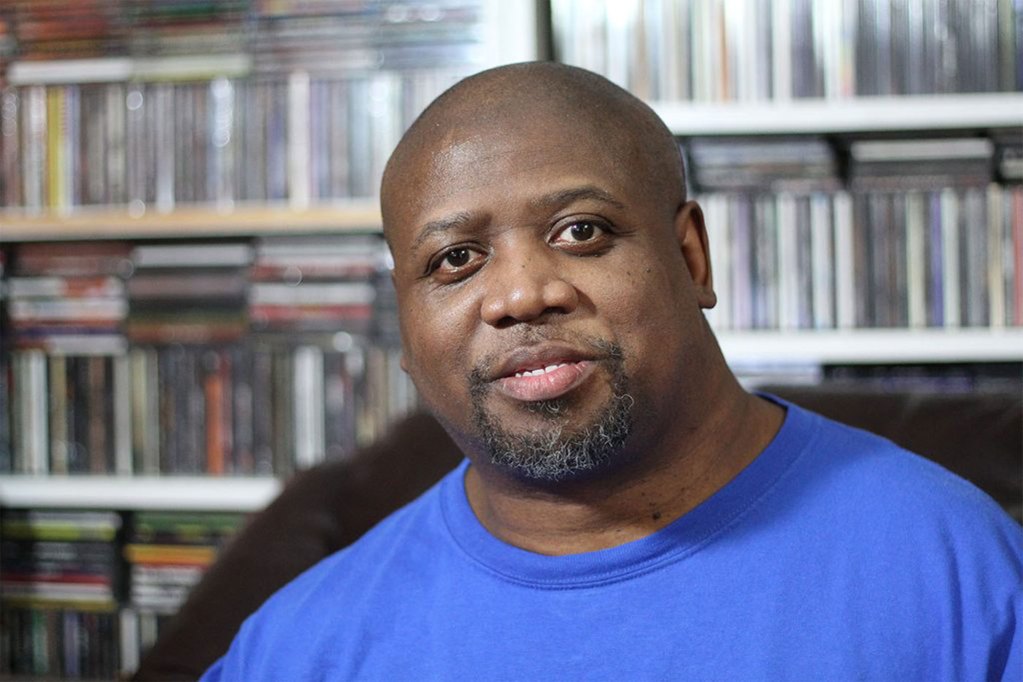 a headshot shows a man looking at the camera