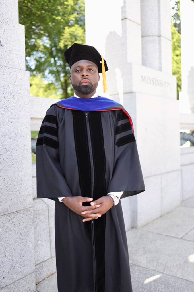 Man in cap and gown for a grad ceremony.
