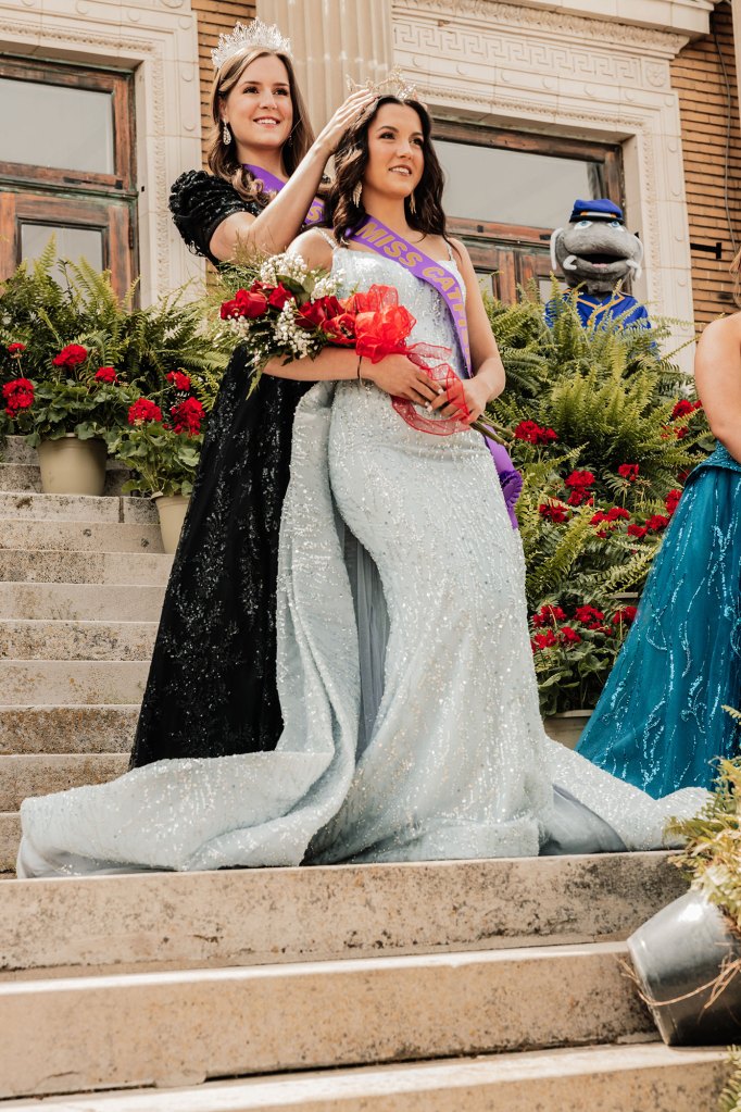 Two women apart of the Little Miss Catfish Pageant stand together in a photo wearing black and silver dresses with crowns on their heads