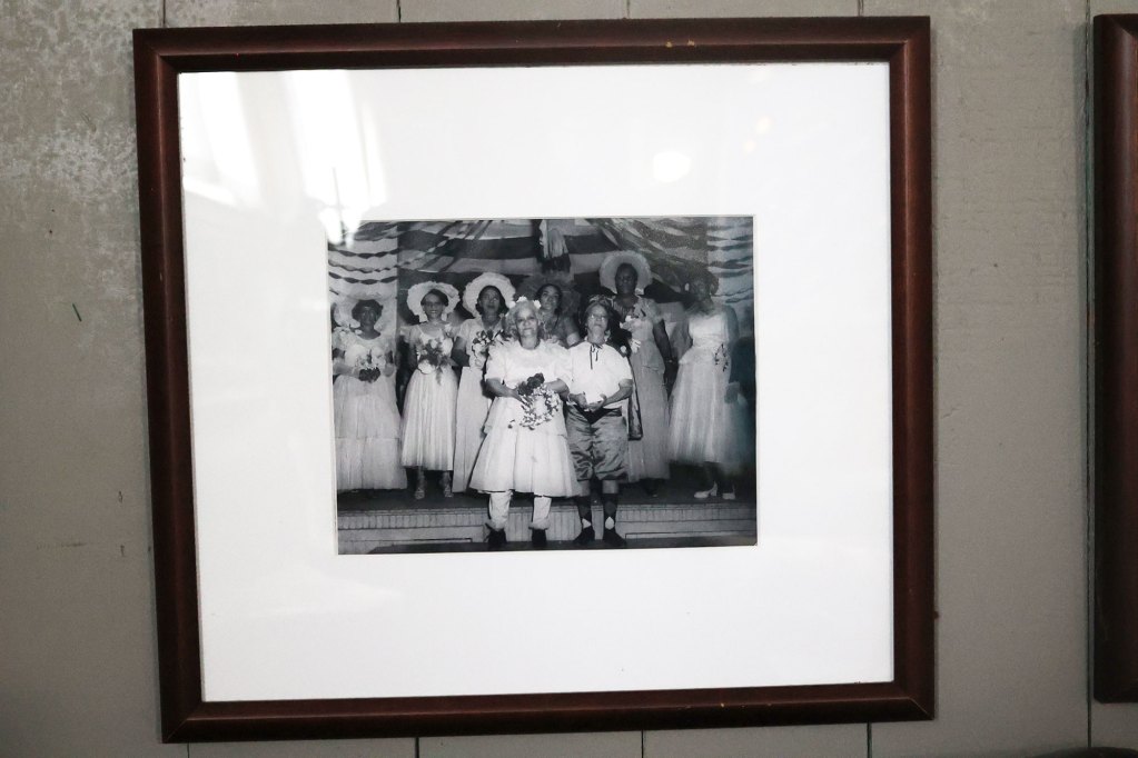 A framed black-and-white photo shows actors dressed as if they were participating in a wedding.