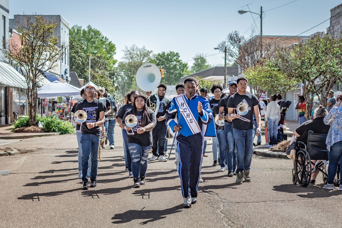 A band marching in the street wearing blue and black.