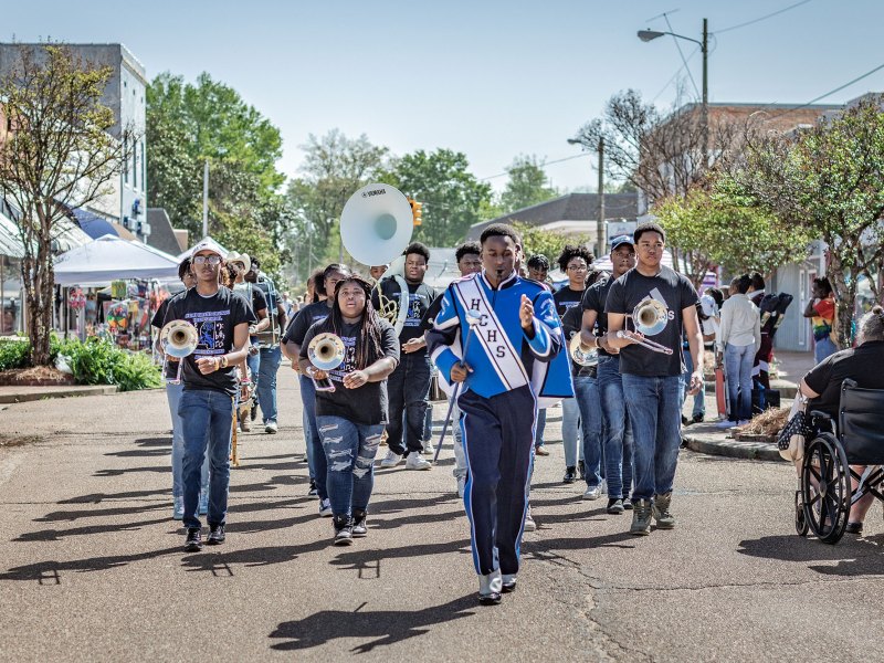 A band marching in the street wearing blue and black.